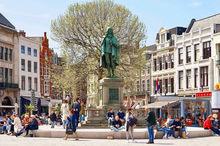 Leute vor einer Statue auf einem Platz in Den Haag