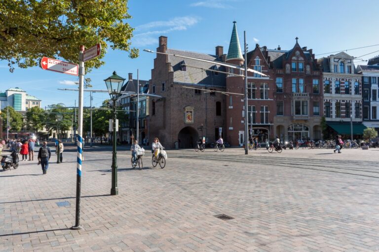 zwei Frauen fahren auf Rädern über einen Platz in Den Haag