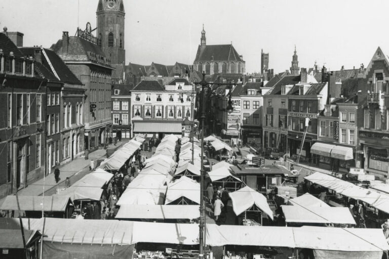 Marktstände auf einem Platz in den Niederlanden, Kirchen im Hintergrund