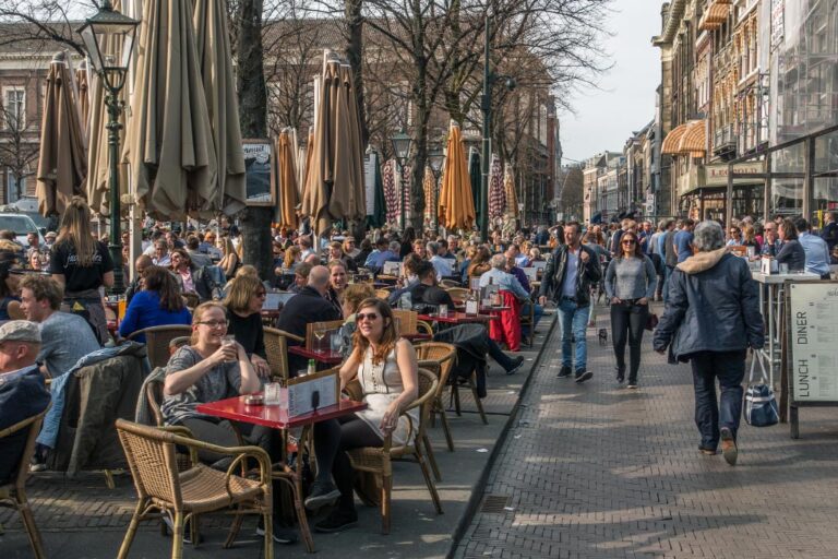 Leute sitzen in Gastgärten, Fußgänger, Schirme, Bäume, Niederlande, autofreier Platz