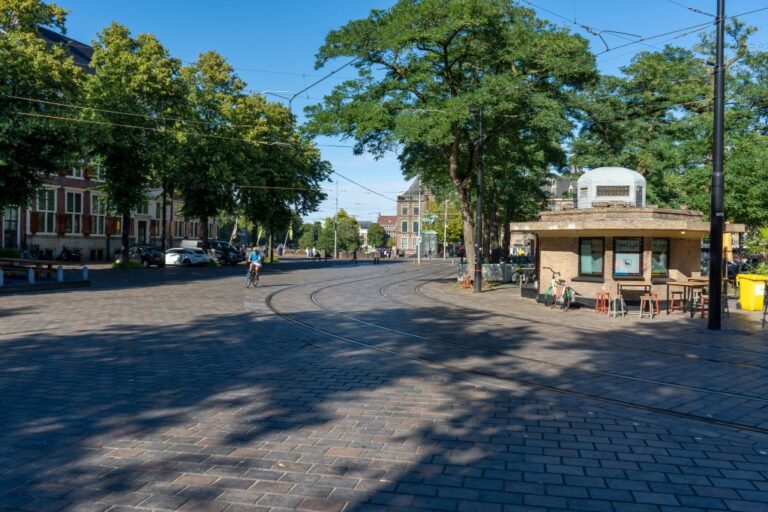 Platz in Den Haag, Kiosk, Bäume, Straßenbahngleise, Radfahrer