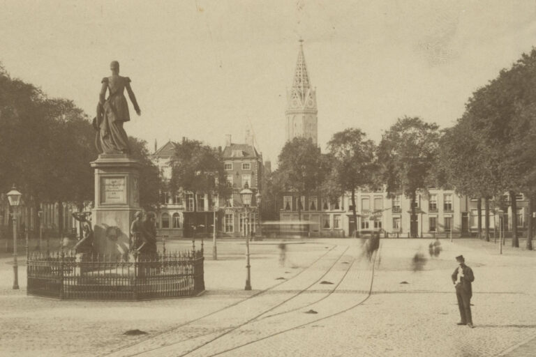 historische Aufnahmen eines Platzes, Statue, Kirchturm, Mann blickt in die Kamera