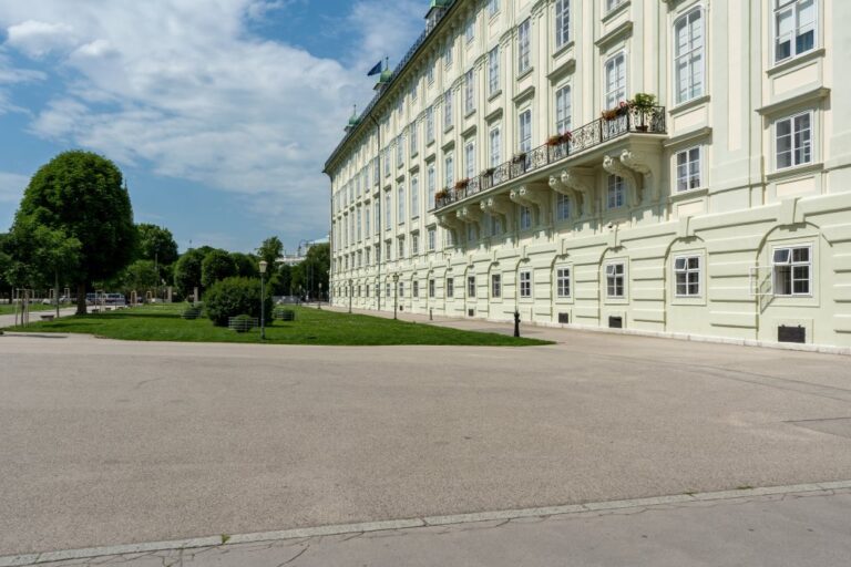 Heldenplatz vor einem barocken Trakt der Hofburg, Bäume, Rasen, Asphalt
