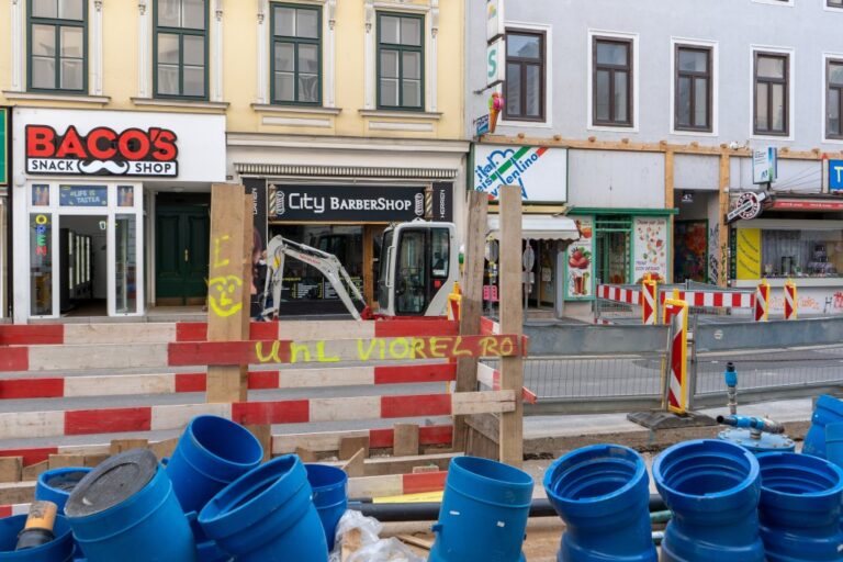 Bauarbeiten auf einer Straße in 1050 Wien, Bagger, Rohre, Absperrungen
