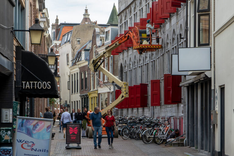 Leute gehen durch eine Straße in Utrecht, Kranwagen, abgestellte Fahrräder