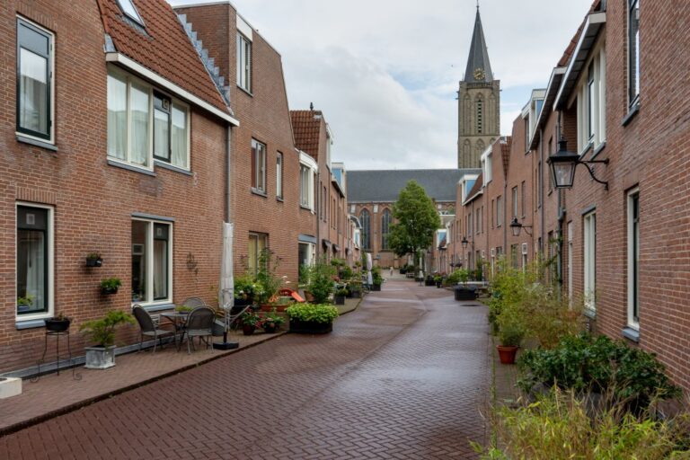 Straße mit niedrigen Häusern auf beiden Seiten, im Hintergrund eine Kirche