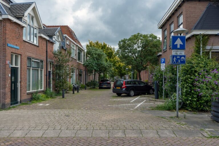 Wohnstraße in den Niederlanden, kleine Häuser, Autos, Verkehrsschilder, Bäume, Schwelle