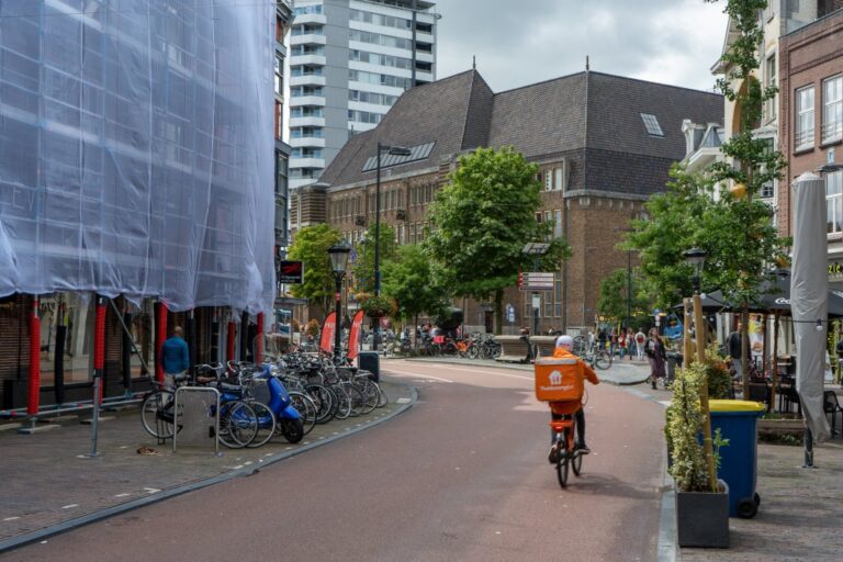 Fahrradfahrer fährt von der Voorstraat in Richtung Neude, ehemaliges Postgebäude