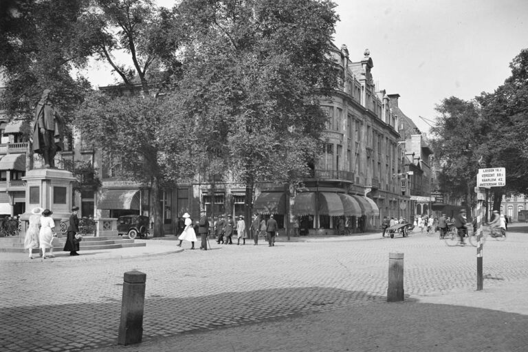 historische Aufnahme eines Platzes in Den Haag, Statue, Bäume, Leute, gepflasterte Straße