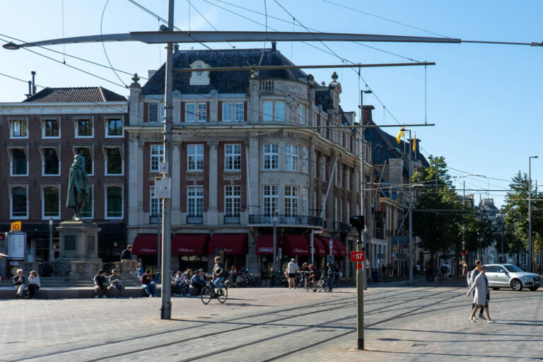 Platz in Den Haag, Oberleitung, Leute, Auto, Statue, alte Häuser