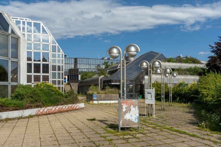 Gebäude mit Glasfassaden, Laternen, Büsche