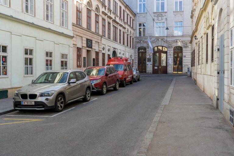 Straße mit parkenden Autos und alten Häusern, Städtisches Bad