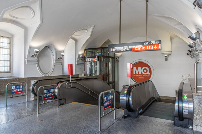 Rolltreppen und Treppe zu einer U-Bahn-Station innerhalb eines historischen Gebäudes