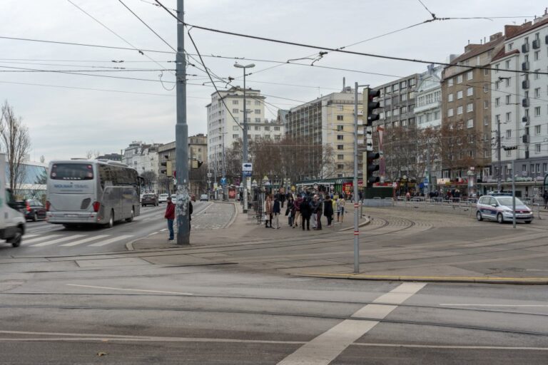 Autoverkehr am Franz-Josefs-Kai, Leute warten an einer Kreuzung, Straßenbahnschienen