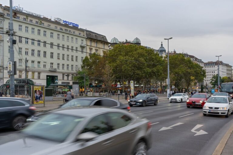 Autos fahren auf mehreren Spuren an einer Häuserzeile vorbei